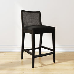 Black modern bar stool with cushioned seat and mesh backrest on wooden floor.