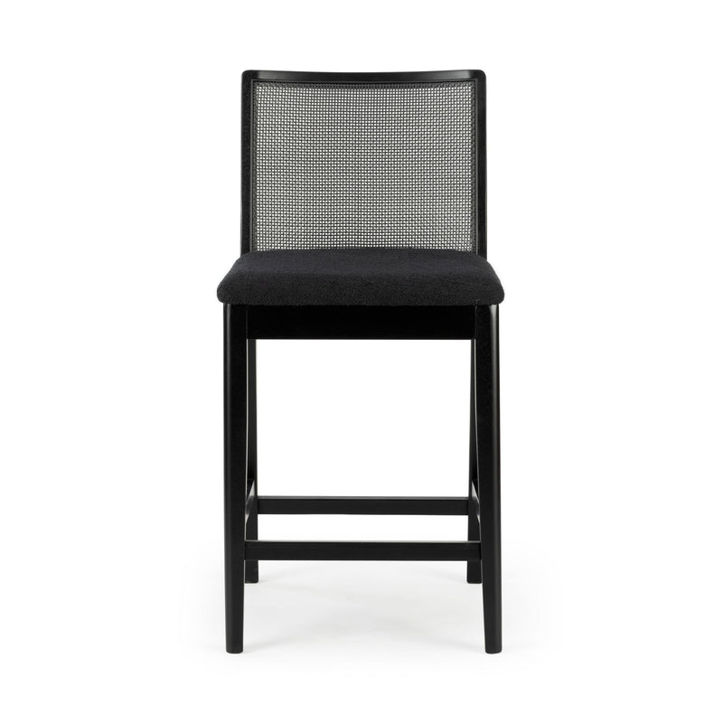 Black wooden counter stool with woven cane backrest, padded black upholstered seat and footrest, modern mid-century bar stool