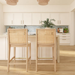 Bright modern coastal kitchen island with two rattan-back bar stools, white shaker cabinets, blue subway tile backsplash, woven pendant lights and light wood flooring