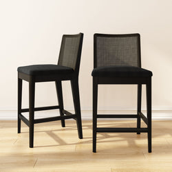 Black wooden bar stools with cushioned seats on a hardwood floor.