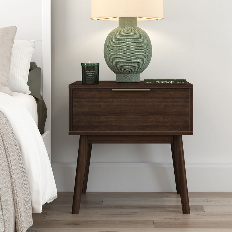 Mid-century modern wooden bedside table with green lamp and candle, styled in a contemporary bedroom.