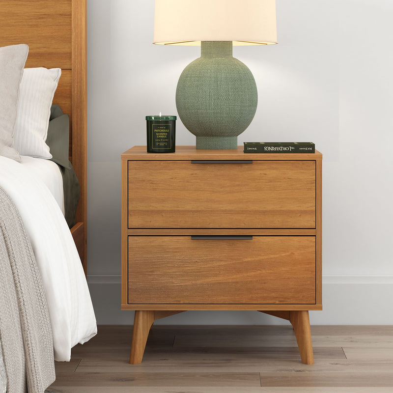 Mid-century modern wooden nightstand with two drawers, featuring a decorative table lamp and a green scented candle, enhancing bedroom decor.