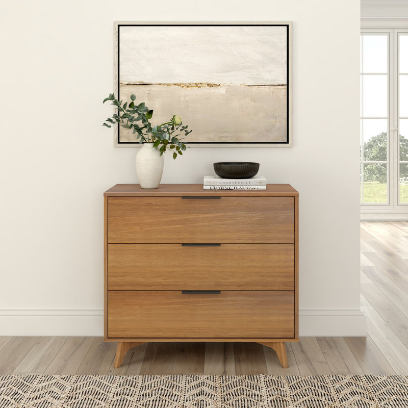 Mid-century modern wooden dresser with decorative vase and artwork in minimalist living room.