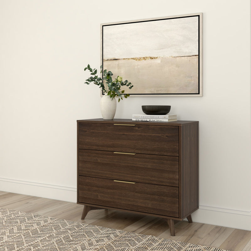 Stylish modern dresser with a dark wood finish, featuring three drawers and decorative tabletop items, set in a minimalist room with a textured area rug and abstract wall art.