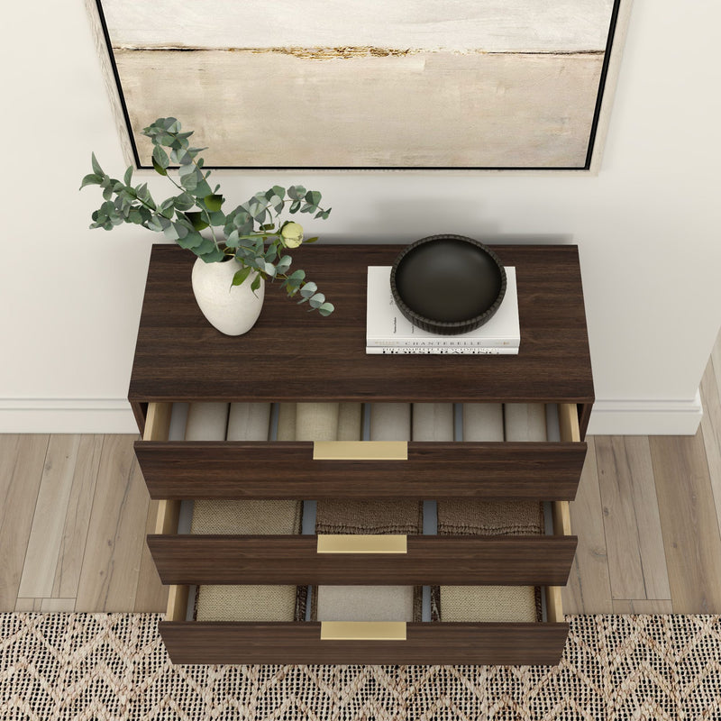Dark wood dresser with brass handles, open drawers displaying neatly folded blankets, topped with a vase of green leaves and decorative items, enhancing modern home decor.