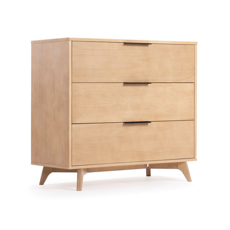 Mid-century modern three-drawer light wood dresser with black handles and tapered legs — natural oak bedroom storage