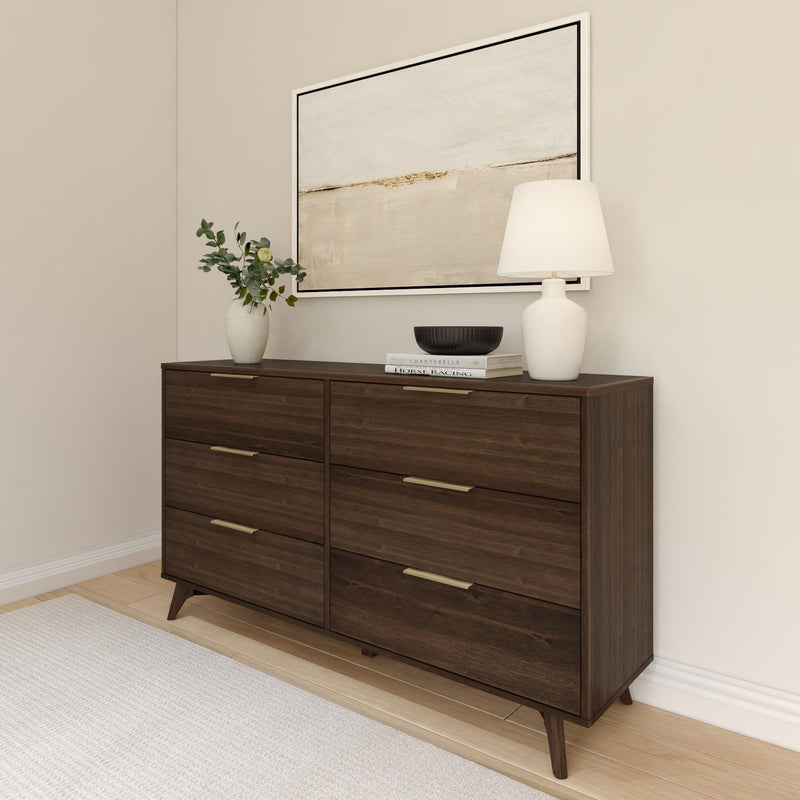 Modern wooden dresser with six drawers, decorated with a lamp, vase, and books in a minimalist bedroom setting.