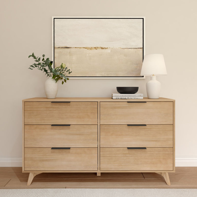 Minimalist wooden dresser with abstract wall art, decorative vase, lamp, and books in a beige modern living room setting.