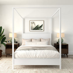 Modern minimalist bedroom with a white four-poster canopy bed, neutral cozy bedding, wooden nightstands with lamps, palm wall art and indoor plant