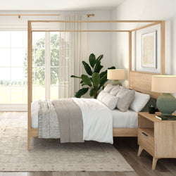 Modern Scandinavian bedroom with natural wood four-poster bed, neutral cozy bedding, large window with sheer curtains, bedside lamps and indoor plant