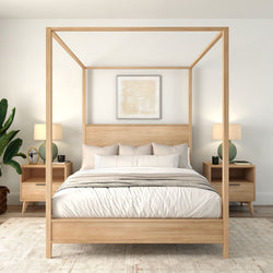 Minimalist modern bedroom with natural wood four‑poster canopy bed, white linens, matching nightstands, table lamps and indoor plant