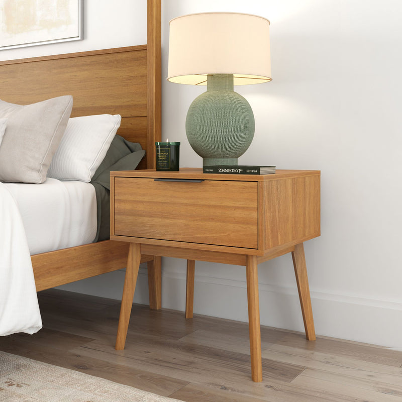 Mid-century modern wooden nightstand with lamp and books in a stylish bedroom setting.
