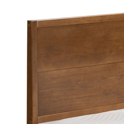 Close-up of brown solid wood panel headboard with visible side mounting hardware and white mattress edge, modern bed frame