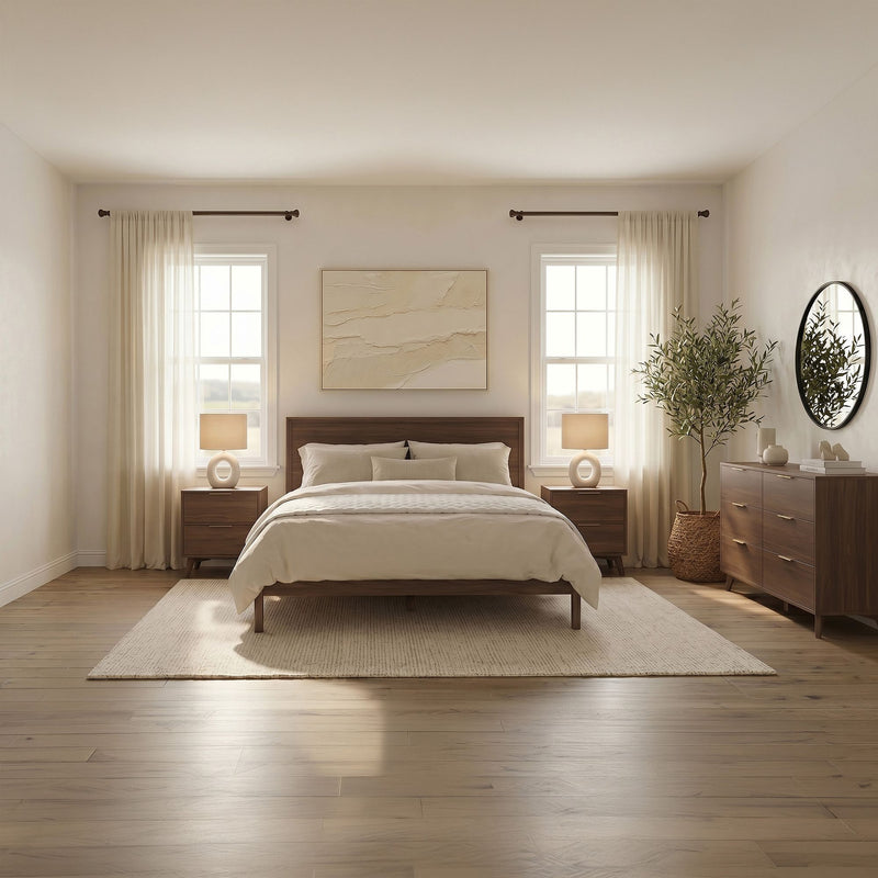 Minimalist modern bedroom with wood bed frame, neutral bedding, matching nightstands and lamps, sheer curtains, round mirror and potted plant bathed in natural light