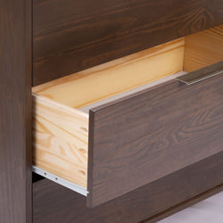 Close-up of a dark walnut-stained dresser drawer with light pine interior, metal handle and white drawer slide, modern wood furniture detail