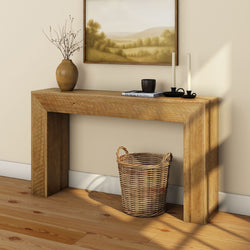 Rustic wooden console table with decorative vase, candles, and wicker basket in a cozy living room setting.