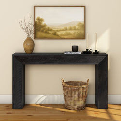 Elegant black console table with decor and wicker basket, wall art background.
