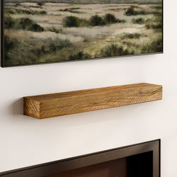 Rustic reclaimed wood floating mantel shelf mounted above a modern fireplace beneath landscape wall art, farmhouse living room decor