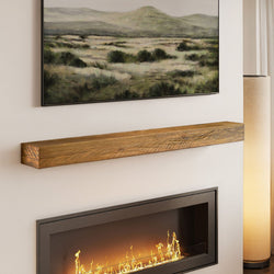 Floating reclaimed wood mantel shelf above modern recessed electric fireplace with landscape wall art and floor lamp
