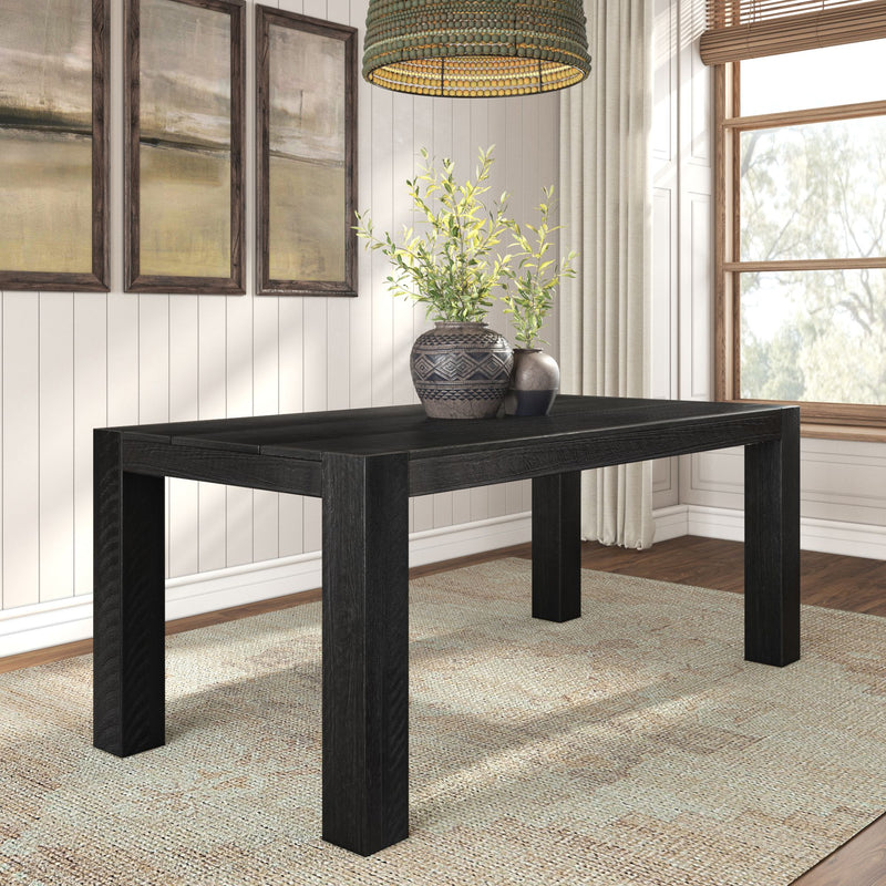 Modern black wood rectangular dining table in a sunlit farmhouse dining room with woven rug, pendant light, framed wall art and ceramic vases