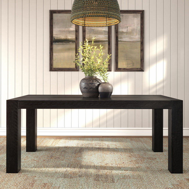 Black wood dining table with decorative ceramic vases and green foliage under a woven rattan pendant light, framed abstract art on a neutral shiplap wall and textured area rug