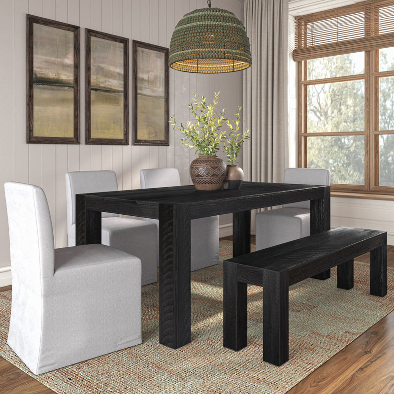 Modern farmhouse dining room with black wooden table and bench, white slipcovered chairs, woven pendant light, decorative vases with greenery, large window and neutral wall art