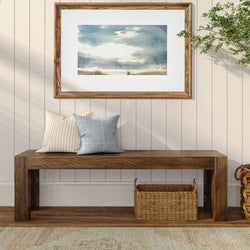 Modern rustic living room with wooden bench, decorative pillows, framed landscape art, and woven basket storage.