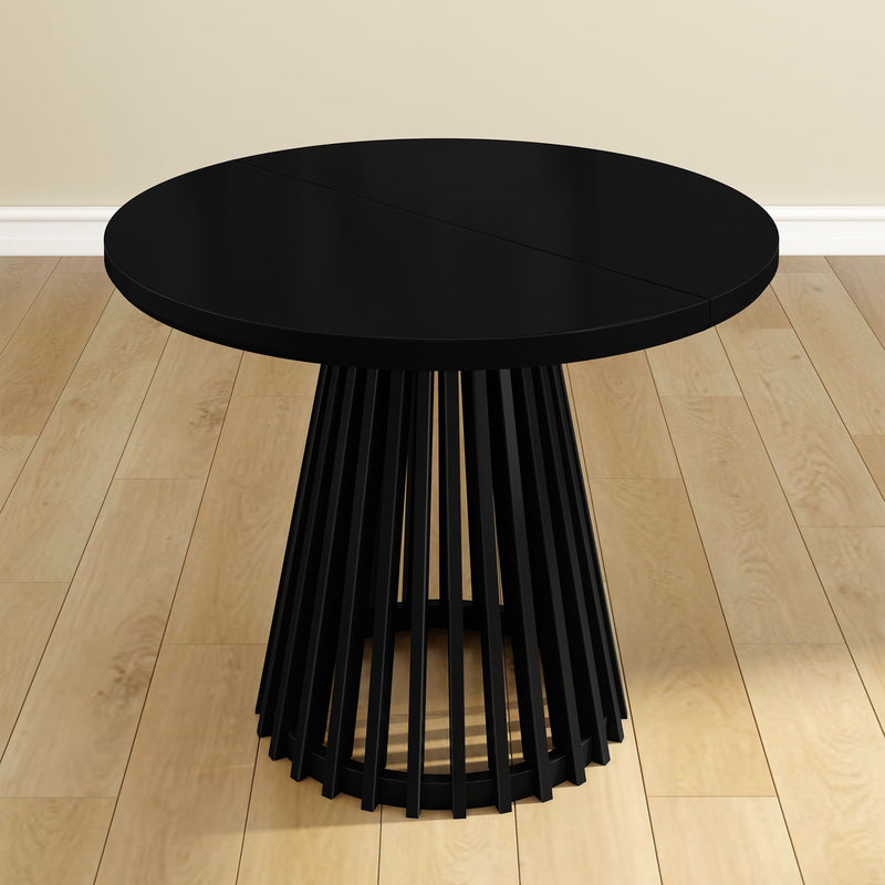 Round black modern dining table with slatted base on wood floor.