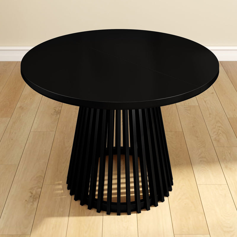 Black round modern dining table on wooden floor.