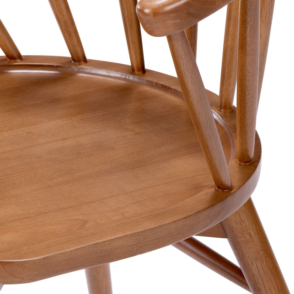Close-up of a wooden chair with a rounded seat and vertical slats, showcasing high-quality craftsmanship and natural finish.