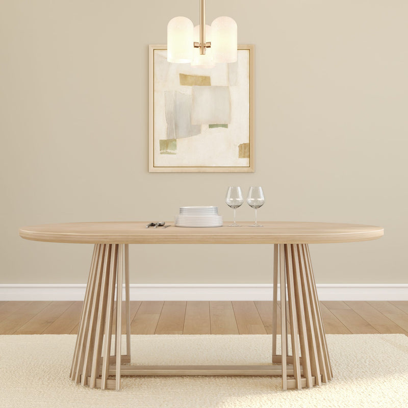 Modern Scandinavian dining room with light wood oval table and slatted pedestal base, neutral beige walls, abstract framed art, pendant light, stacked plates and two wine glasses