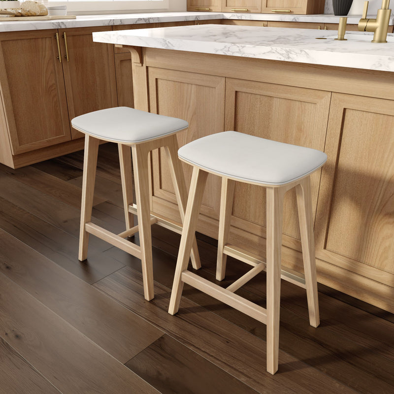 Modern wooden bar stools with white cushions in a stylish kitchen setting.