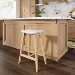 Light oak kitchen island with white marble countertop, brass wall-mounted faucet and minimalist wooden bar stool on dark hardwood floor