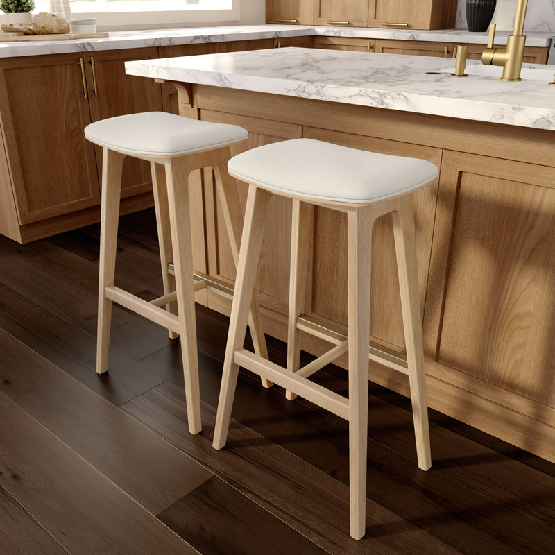 Modern wooden bar stools with white cushions in a stylish kitchen setting featuring marble countertops and wooden cabinets.