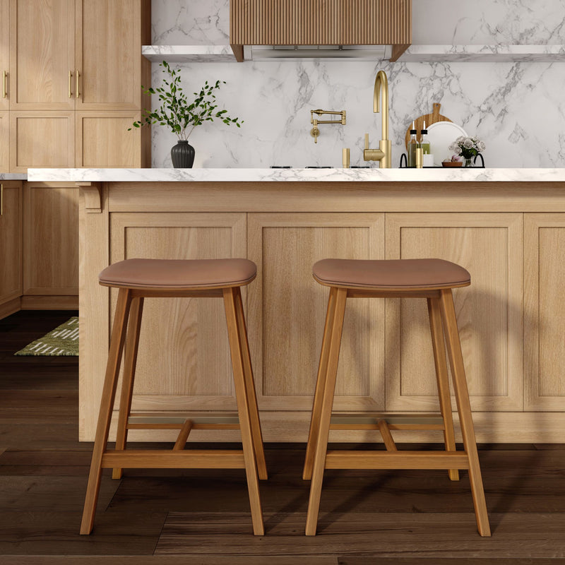 Modern kitchen with wooden bar stools and marble countertop.