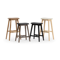 Four modern wooden bar stools with upholstered seats (black, brown, cream) in mixed wood finishes on white background