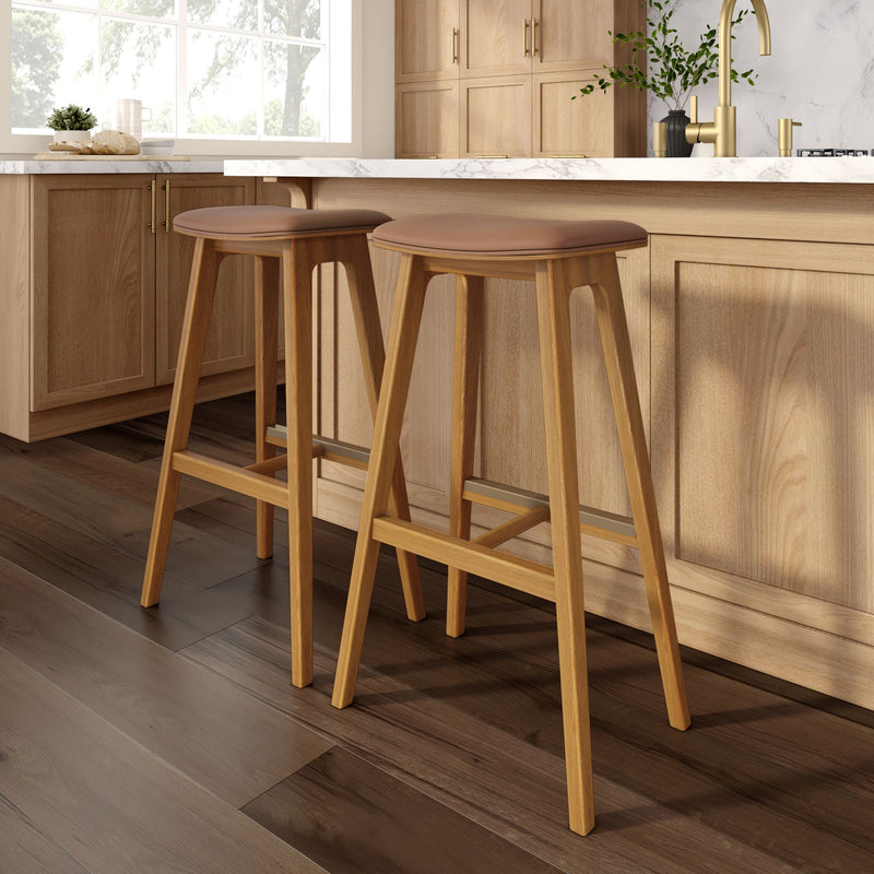 Two modern wooden bar stools with leather seats at a stylish kitchen island, highlighting contemporary kitchen design.
