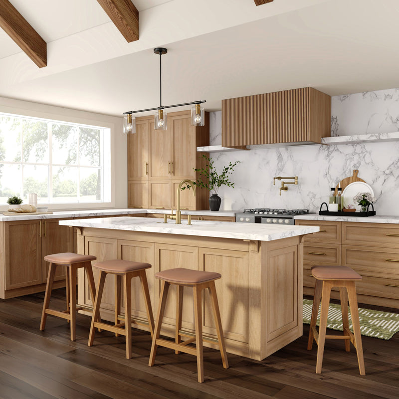 Bright modern farmhouse kitchen with light oak cabinets, white marble countertops and backsplash, large island with brass faucet, four wooden bar stools, pendant lighting and dark hardwood floors