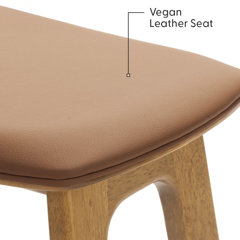 Tan vegan leather seat cushion on oak wood dining stool, padded faux leather upholstery with textured finish, mid-century modern design