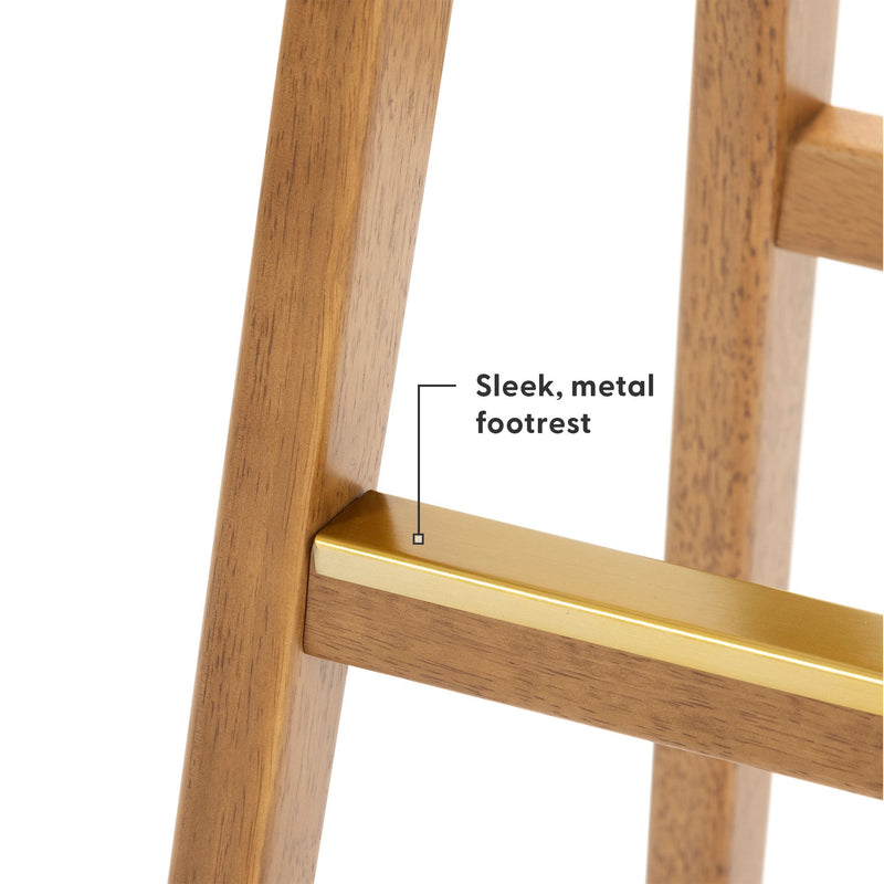 Close-up of warm wood finish bar stool leg with gold-tone metal footrest, modern mid-century style bar stool detail
