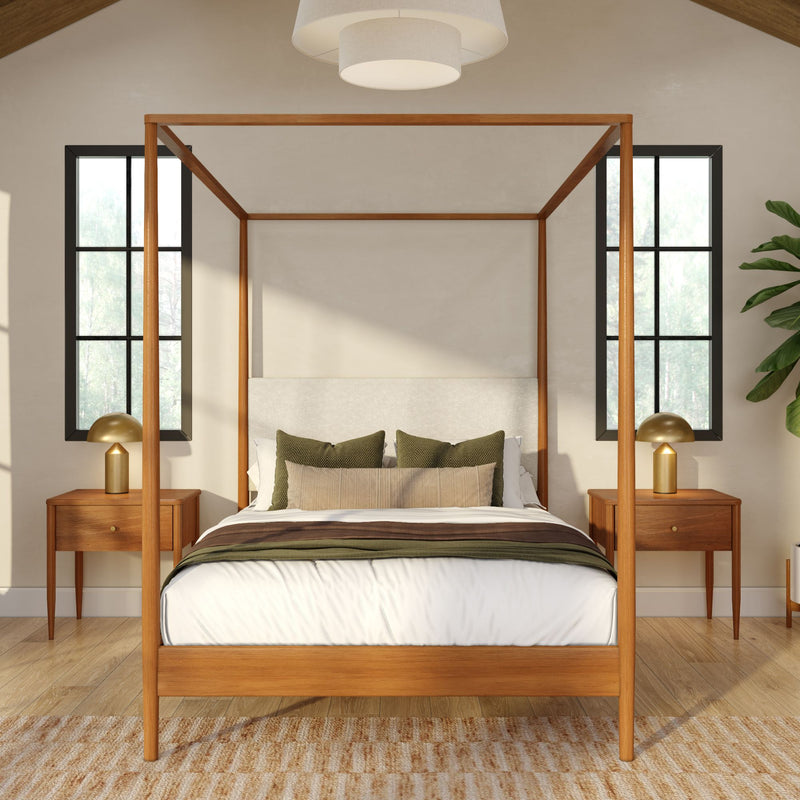 Modern farmhouse bedroom with wooden four-poster bed, neutral bedding, green accent pillows, brass bedside lamps and black-framed windows