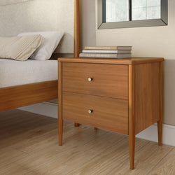 Mid-century modern wooden nightstand beside bed with striped pillow, stacked hardcover books and window in minimalist bedroom interior