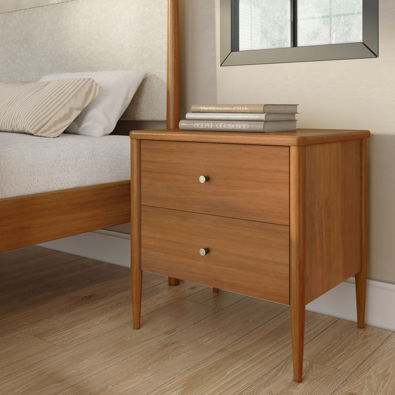 Mid-century modern wooden nightstand beside bed with striped pillow, stacked hardcover books and window in minimalist bedroom interior