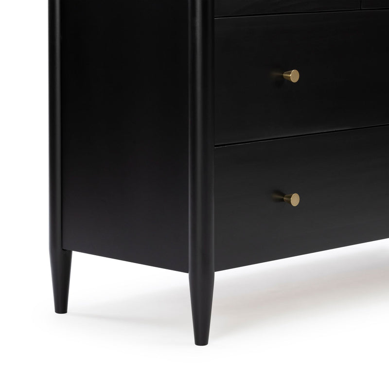 Black mid-century modern wooden dresser close-up showing tapered legs and two drawers with brass knobs, matte finish bedroom storage furniture