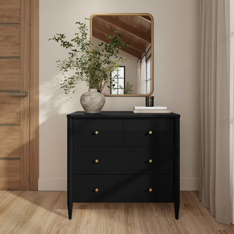 Minimalist Scandinavian entryway with a modern black dresser with gold knobs, rustic ceramic vase of greenery, rounded-corner wall mirror, natural wood floor and neutral curtains
