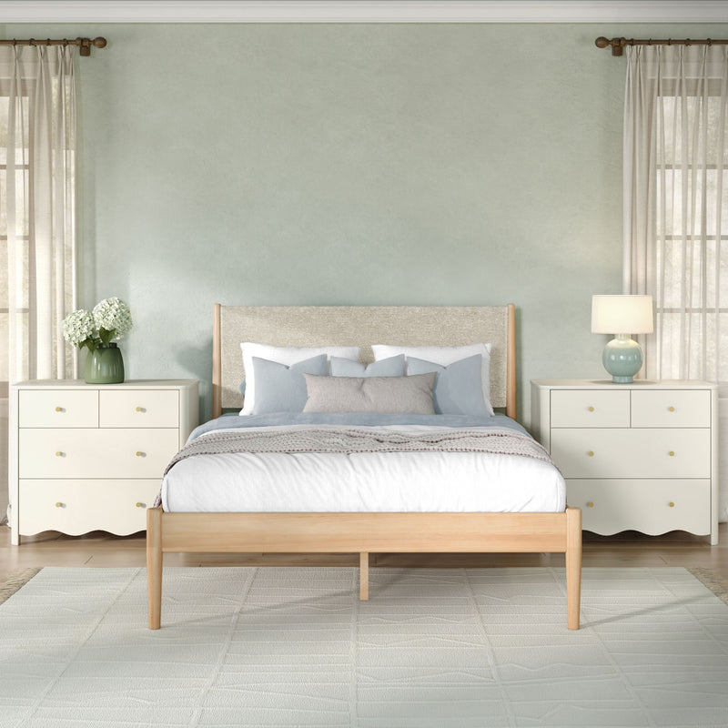 Modern cozy bedroom with soft green accent wall, light wood bed frame, matching nightstands, lamp, vase of white hydrangeas and sheer curtains