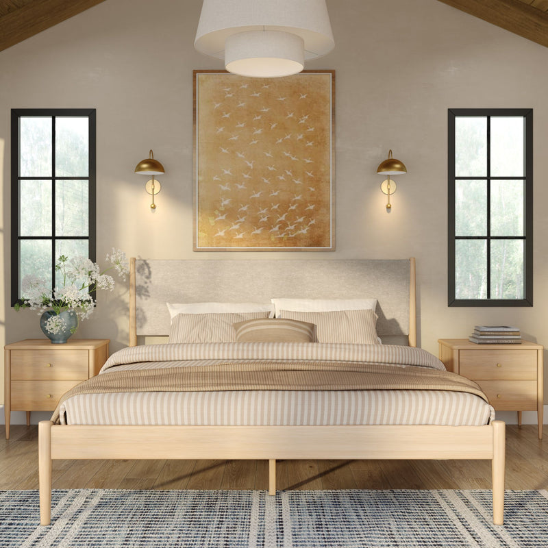 Modern minimalist bedroom interior with wooden platform bed, striped beige bedding, matching bedside tables, gold wall sconces, bird artwork and large windows