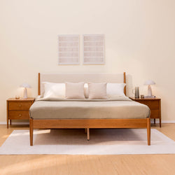 Mid-century modern wooden bed with neutral bedding, matching nightstands and lamps, minimalist wall art on hardwood floor