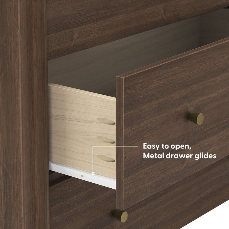Close-up of modern walnut dresser drawer with metal drawer glides, dovetail joints, brass knobs and light wood interior