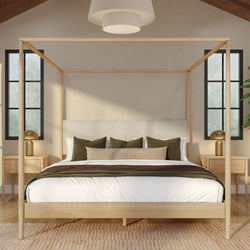 Modern minimalist bedroom with light wood four-poster canopy bed, neutral bedding, green accent pillows and matching nightstands